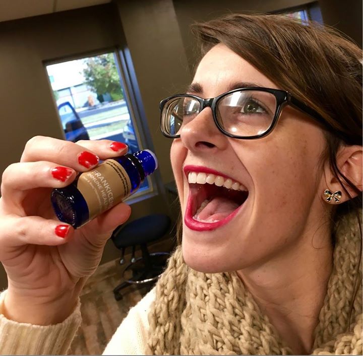 Picture of a young women about to drink from an essential oil bottle